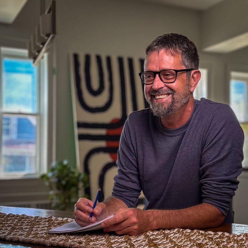 Mike Dolinsek, personal development coach, taking notes during a coaching session